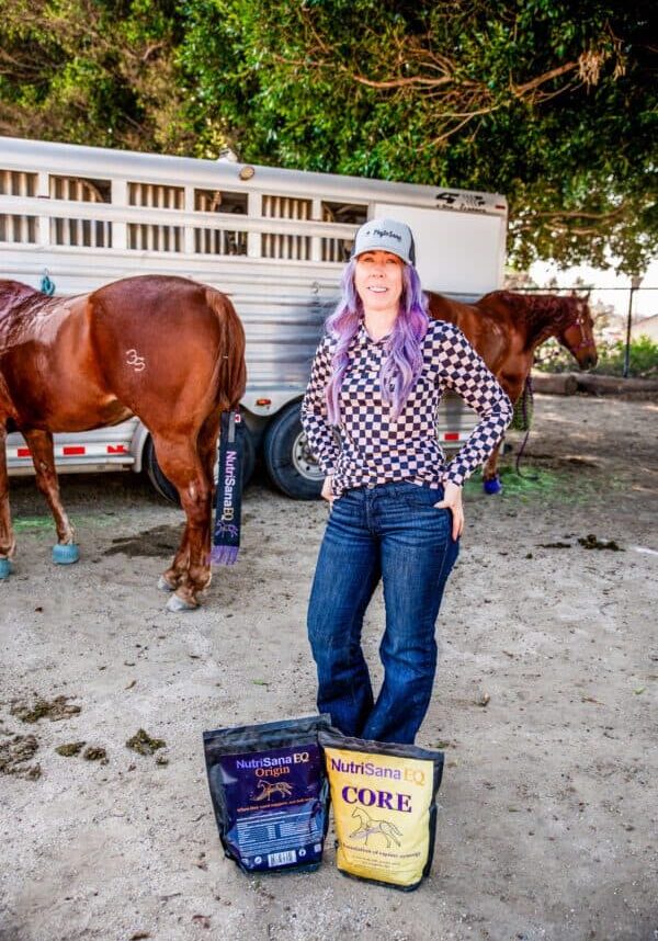 Woman with horse supplements at stables, promoting equine health and nutrition.